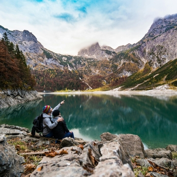 a couple looking at an alpine lake.