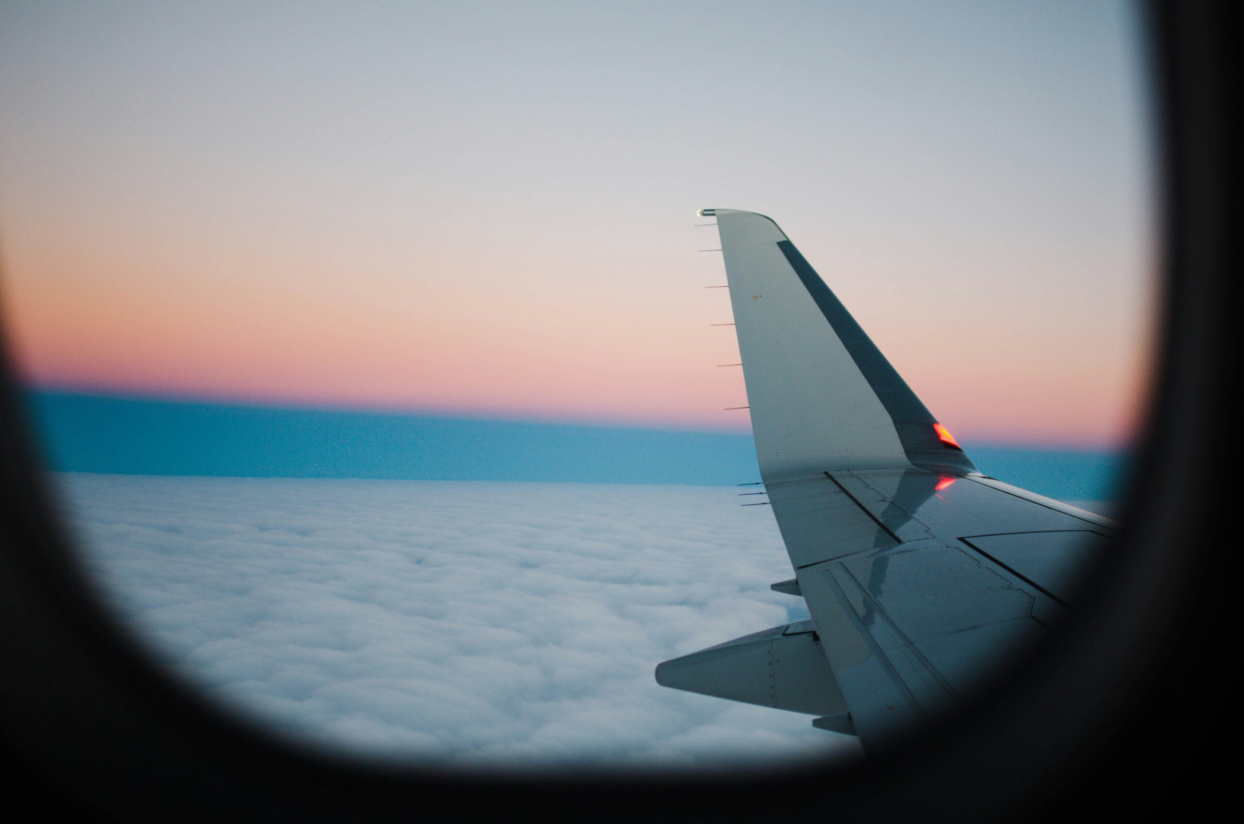 the wing of an airplane against the clouds.