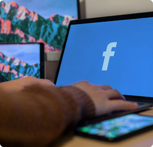 a laptop with the facebook logo on the screen.