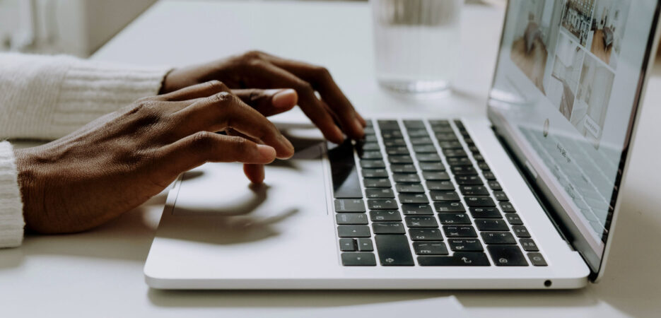hands typing on a laptop keyboard.