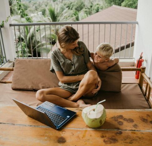 a woman and kid looking at a laptop.