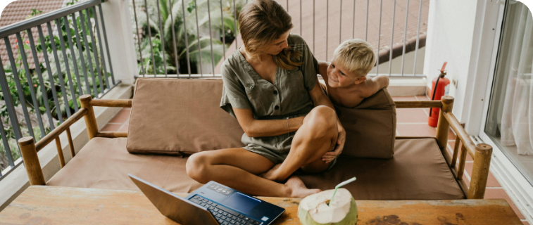 a woman and kid looking at a laptop.
