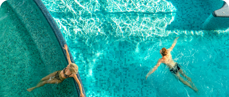 a man and a woman swimming in a pool